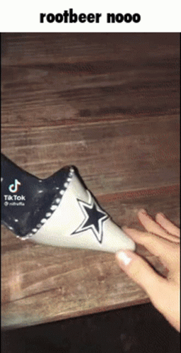 A Person Is Holding A Cone With A Cowboys Star On It . GIF