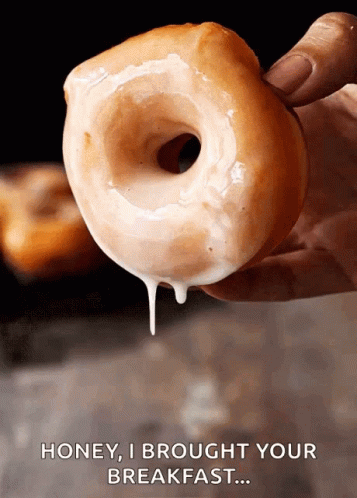 A Person Is Holding A Glazed Donut With The Words Honey I Brought Your Breakfast Above It GIF