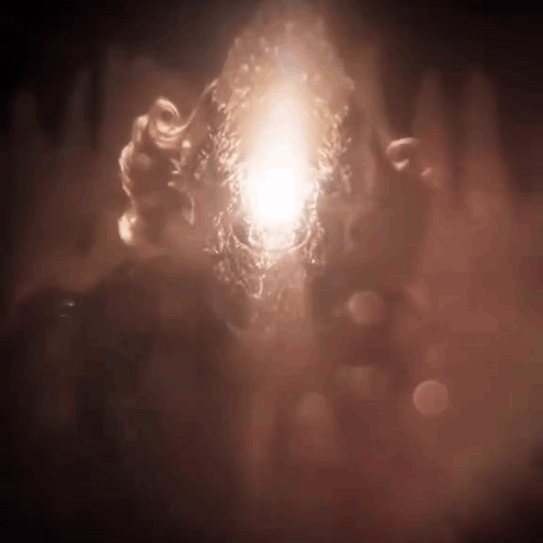 a person is holding a glowing object in their hands in the dark .
