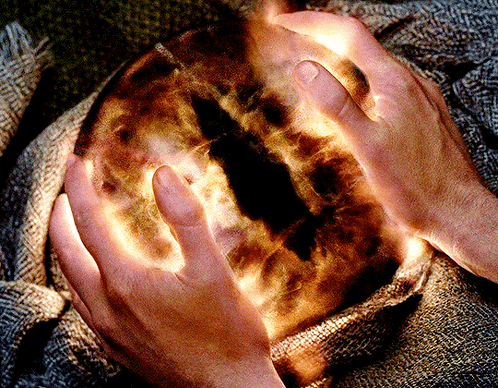 A Person Is Holding A Glowing Sphere In Their Hands GIF