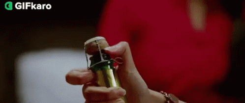 A Person Is Holding A Green Bottle With Smoke Coming Out Of It And Giving A Thumbs Up . GIF