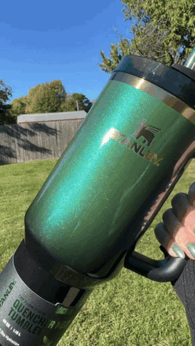 A Person Is Holding A Green Stanley Tumbler In Their Hand GIF