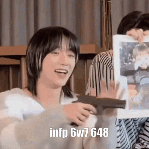 A Person Is Holding A Gun And A Picture Of A Person In A Frame . GIF