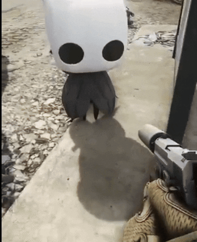 A Person Is Holding A Gun Next To A Stuffed Animal With Black Eyes GIF