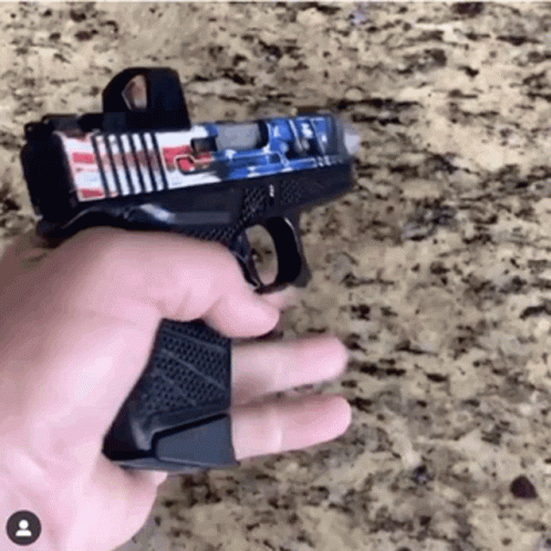 A Person Is Holding A Gun With An American Flag Sticker On It GIF
