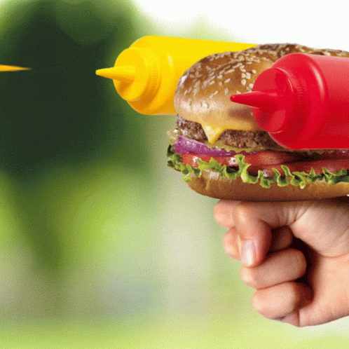 A Person Is Holding A Hamburger With Two Bottles Of Mustard And Ketchup GIF