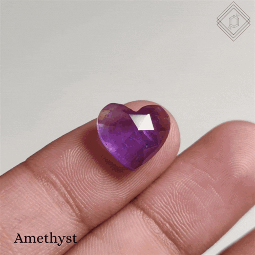 A Person Is Holding A Heart Shaped Amethyst In Their Hand GIF