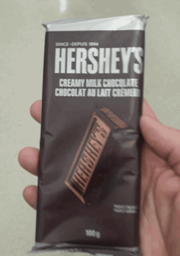 A Person Is Holding A Hershey 'S Bar In Their Hand GIF