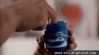 A Person Is Holding A Jar Of Vaporub . GIF