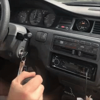 A Person Is Holding A Key In Their Hand In The Car GIF
