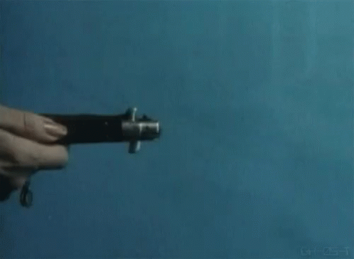 a person is holding a knife in their hand against a blue wall .