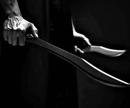 A Person Is Holding A Large Knife In Their Hand GIF