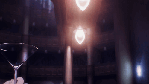A Person Is Holding A Martini Glass In Front Of A Light GIF