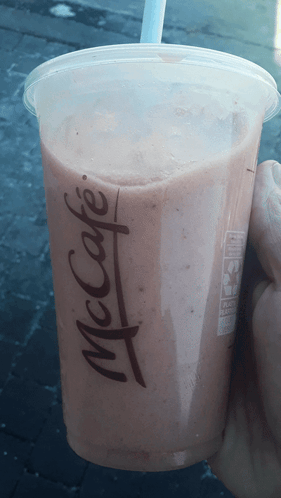 A Person Is Holding A Mcdonald 'S Cup With A Straw GIF