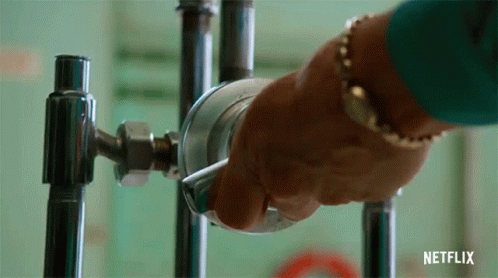 A Person Is Holding A Metal Object In Their Hand . GIF