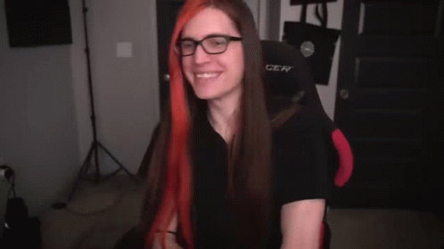 A Person Is Holding A Pair Of Scissors In Their Hands And Cutting A Piece Of Red Hair . GIF