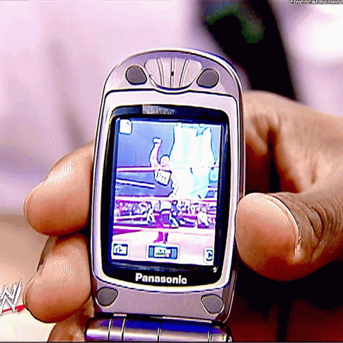 A Person Is Holding A Panasonic Flip Phone In Their Hands GIF