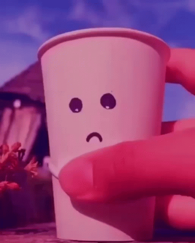 A Person Is Holding A Paper Cup With A Sad Face Drawn On It GIF