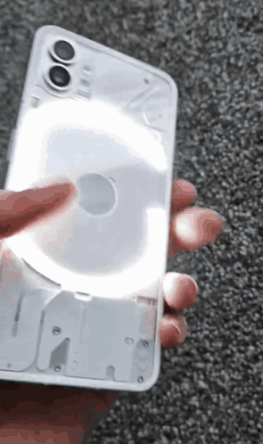 A Person Is Holding A Phone That Has A Light On It GIF