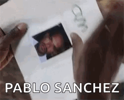 A Person Is Holding A Picture Of A Man In Their Hands . GIF