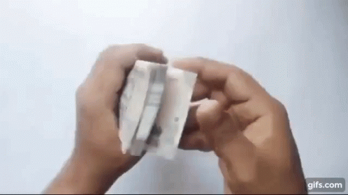 A Person Is Holding A Piece Of Paper That Looks Like A Piece Of Tissue Paper . GIF
