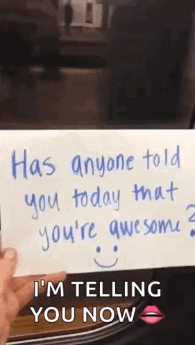 A Person Is Holding A Piece Of Paper That Says `` Has Anyone Told You Today That You 'Re Awesome ? `` GIF
