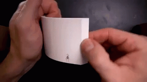 A Person Is Holding A Piece Of Paper With A Drawing On It . GIF