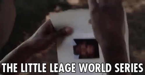 A Person Is Holding A Piece Of Paper With A Picture Of A Person On It . GIF