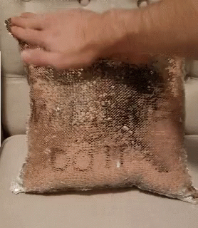 A Person Is Holding A Pillow With The Word Love Written On It . GIF