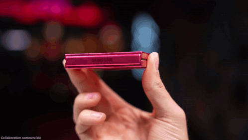 A Person Is Holding A Pink Samsung Device In Their Hand GIF