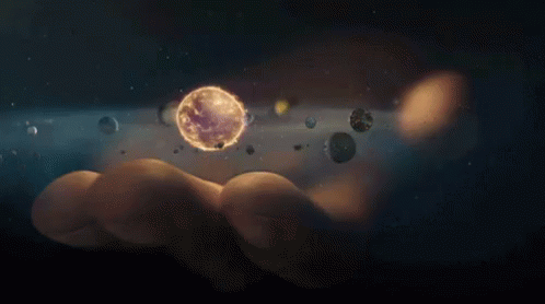 A Person Is Holding A Planet In Their Hand Surrounded By Planets GIF