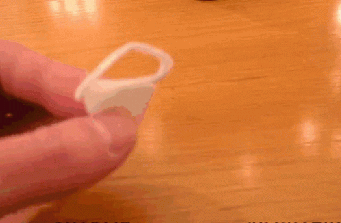 A Person Is Holding A Plastic Ring In Front Of A Pot With Charlie Written On It GIF