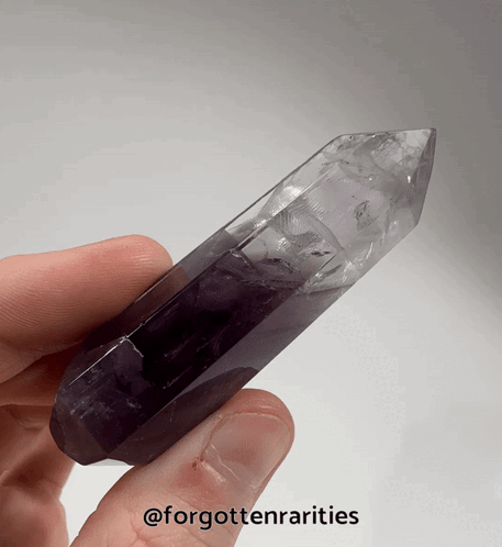 A Person Is Holding A Purple Crystal In Their Hand With The Words Forgottenrarities On The Bottom GIF