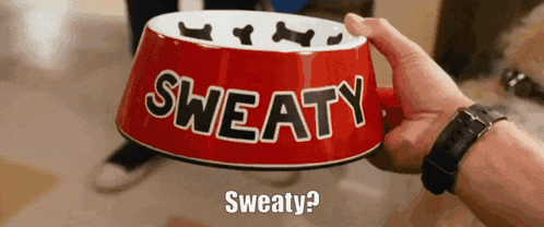 A Person Is Holding A Red Bowl That Says Sweaty On It GIF