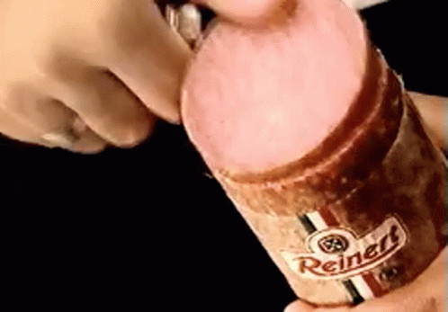 A Person Is Holding A Reinert Sausage In Their Hands GIF