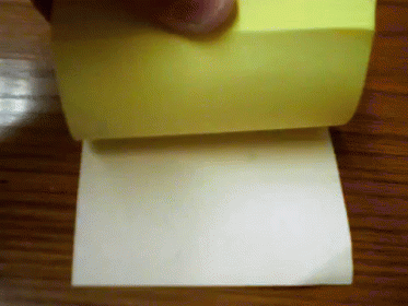 A Person Is Holding A Roll Of Sticky Notes GIF