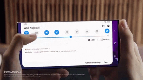 A Person Is Holding A Samsung Dex Phone In Their Hand GIF