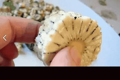 A Person Is Holding A Slice Of Pineapple With A Arrow Pointing To The Left GIF