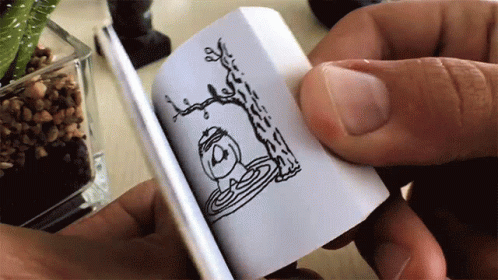 A Person Is Holding A Small Book With A Drawing Of A Tree And A Bird On It GIF