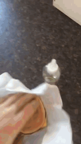 A Person Is Holding A Small Bottle On Their Foot GIF