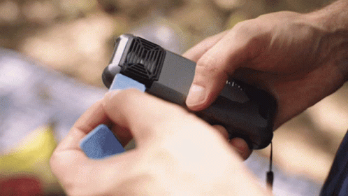 A Person Is Holding A Small Device That Says ' I ' On It GIF