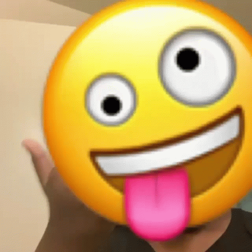 a person is holding a smiley face with a pink tongue sticking out of it .