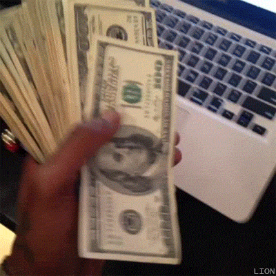 A Person Is Holding A Stack Of 100 Dollar Bills In Front Of A Laptop Keyboard GIF