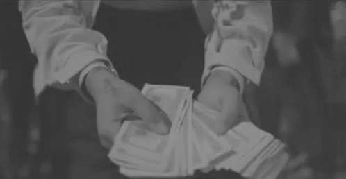 A Person Is Holding A Stack Of Money In Their Hands . GIF
