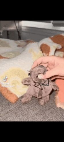 A Person Is Holding A Stuffed Animal That Looks Like A Teddy Bear . GIF