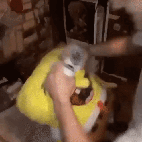 A Person Is Holding A Stuffed Spongebob Doll In Their Hands . GIF