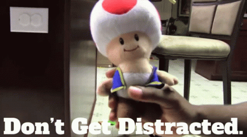 A Person Is Holding A Stuffed Toad With The Words " Do N't Get Distracted " Written Below It GIF