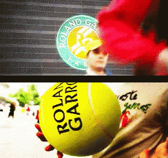 A Person Is Holding A Tennis Ball That Says Roland Garros GIF