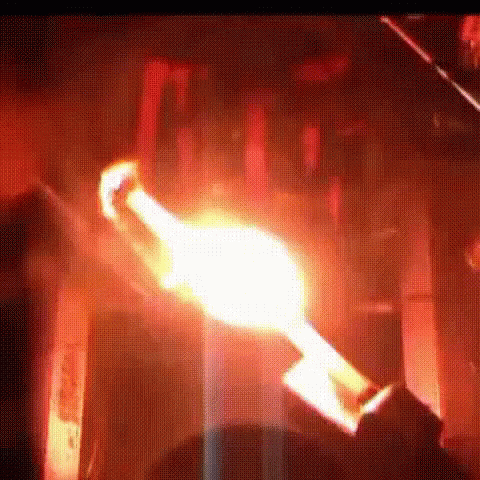 A Person Is Holding A Torch In A Dark Room With A Flame Coming Out Of It . GIF
