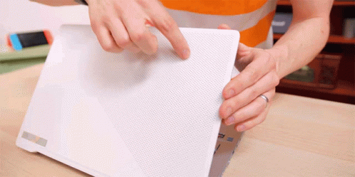 A Person Is Holding A White Laptop With The Letter P On The Back GIF